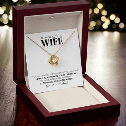 Mahogany style box with LED light holding the love knot pendant necklace in 18k yellow gold finish and the "To My Beautiful Wife" message card from husband