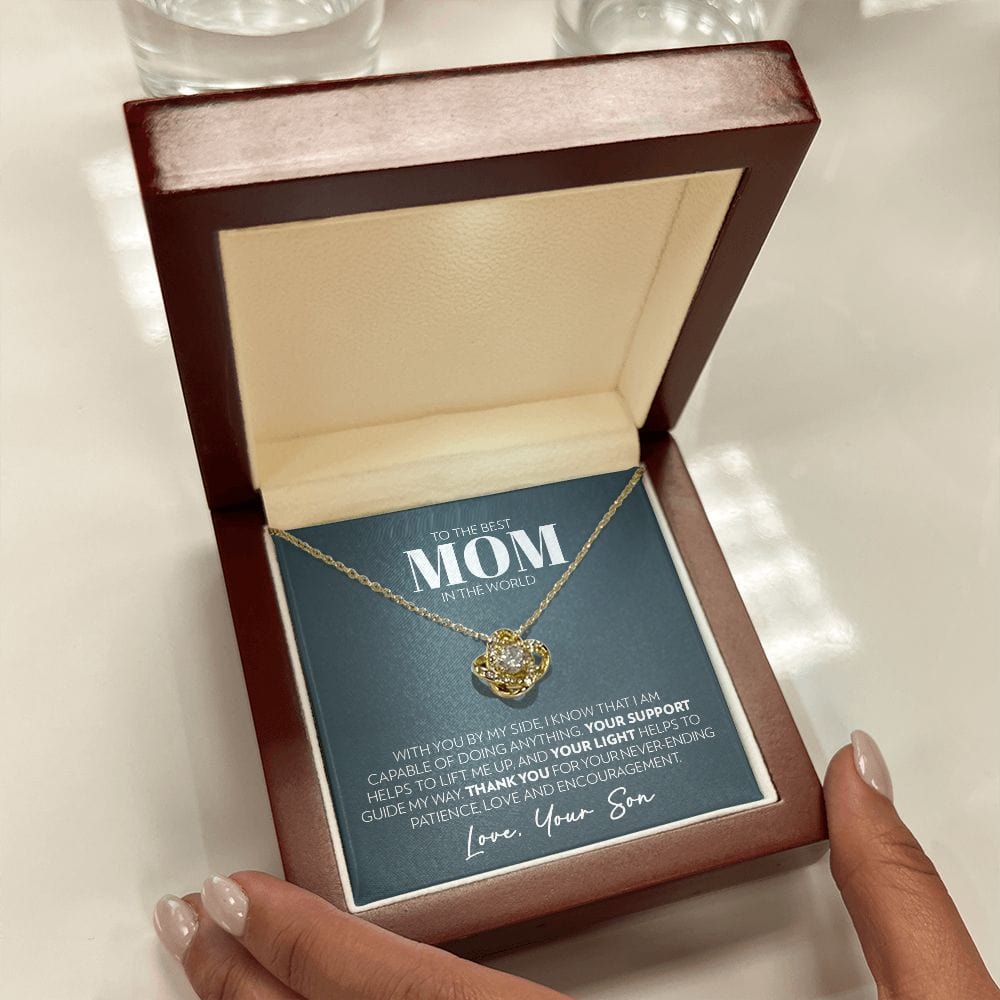 Mahogany style box with LED light holding the love knot pendant necklace in 18k yellow gold finish and the "To the Best Mom in the World" message card from son