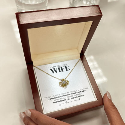 Mahogany style box with LED light holding the love knot pendant necklace in 18k yellow gold finish and the "To My Beautiful Wife" message card from husband