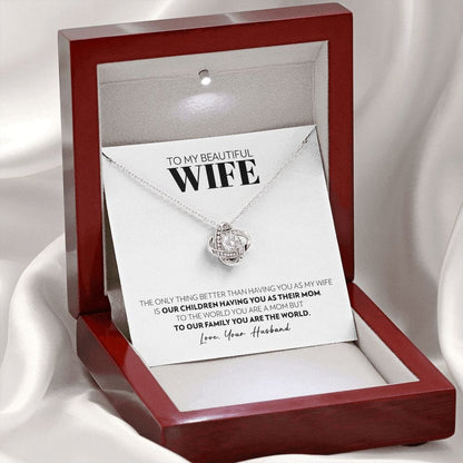 Mahogany style box with LED light holding the love knot pendant necklace in 14k white gold finish and the "To My Beautiful Wife" message card from husband