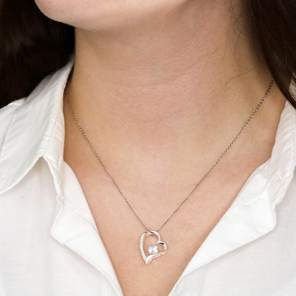 Heart pendant necklace in 14k white gold finish worn by a woman